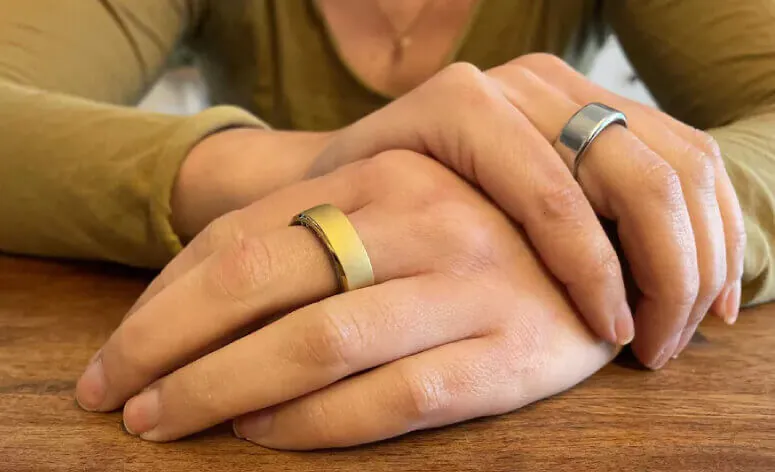 Couple wearing Herz P1 Smart Rings in gold and silver